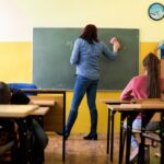 teacher helping student classroom