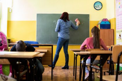 teacher helping student classroom